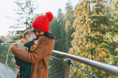 Woman standing by railing during winter