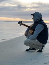 Man playing guitar on beach