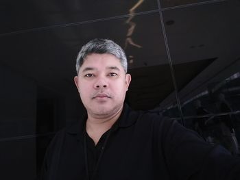 Portrait of man against tiled wall in shop