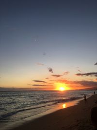 Silhouette man on beach against sky during sunset