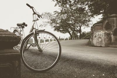 Bicycle by road against sky