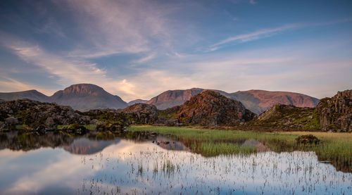 Scenic view of lake by mountains against sky