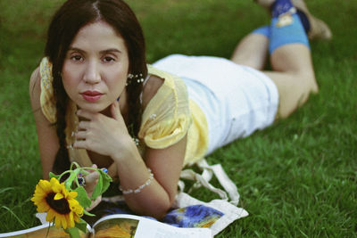 Portrait of woman relaxing on field