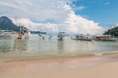 Boats moored on sea against sky