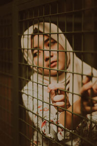 Woman in hijab looking through window