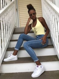 Low angle portrait of teenage girl wearing sunglasses on steps