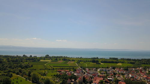 High angle view of town by sea against sky