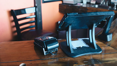 Close-up of credit card reader by computer monitor on table