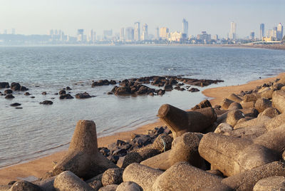 Scenic view of sea by buildings against sky