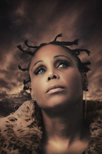 Portrait of beautiful young woman against sky