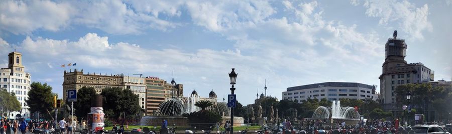 Panoramic view of crowd on street against buildings in city