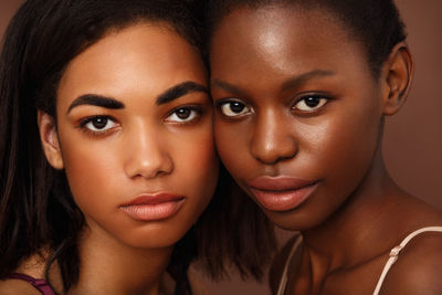 Portrait of females against brown background