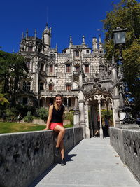 Portrait of woman sitting against palace