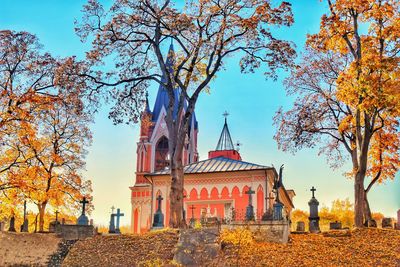 Low angle view of trees and buildings against sky during autumn