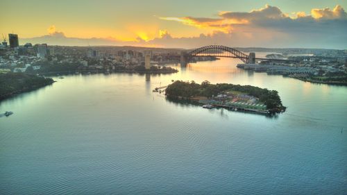 Scenic view of sea and buildings against sky during sunset