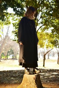 Rear view of woman standing against trees