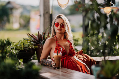 Portrait of young woman looking away sitting on the veranda in the bakery 