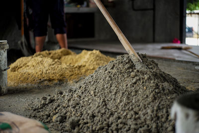 Selective focus on the surface of mixed cement pile with blurred background of sand at the site