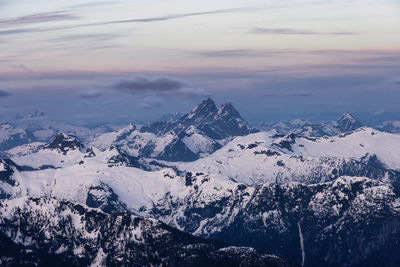 Scenic view of snowcapped mountains against sky during sunset