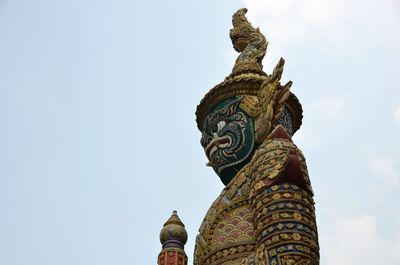 Low angle view of statue against temple building against sky