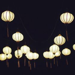 Low angle view of illuminated lanterns hanging at night