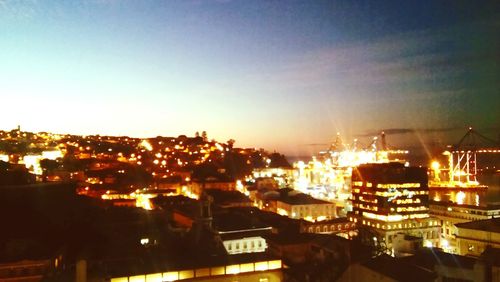 Illuminated cityscape against clear sky at night