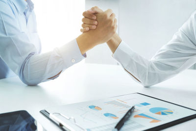 Colleagues arm wrestling on desk