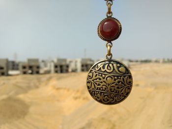 Close-up of metal hanging against clear sky