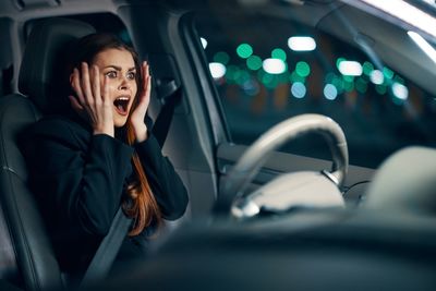 Portrait of young woman sitting in car