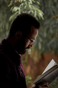 Side view of young man using smart phone outdoors