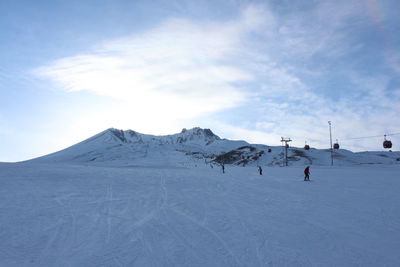People skiing on snowcapped mountain against sky and erciyes