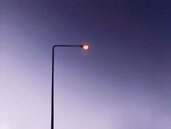 Low angle view of illuminated street light against dramatic sky