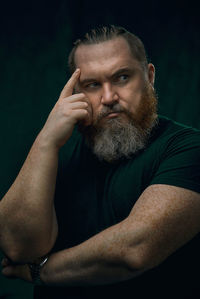 Portrait of senior man against black background