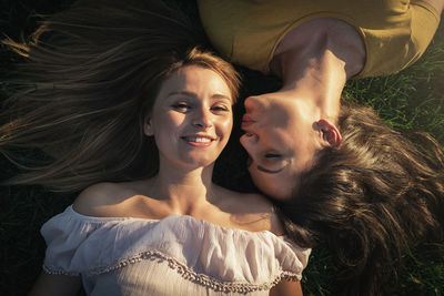 Portrait of smiling friends lying on grass