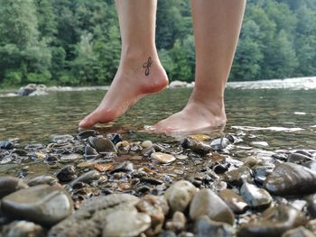 Low section of woman on rock in river