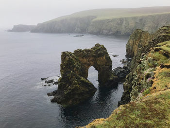 Rock formations by sea against sky