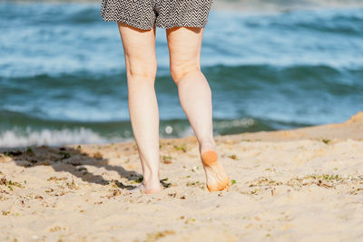 Low section of woman standing on beach