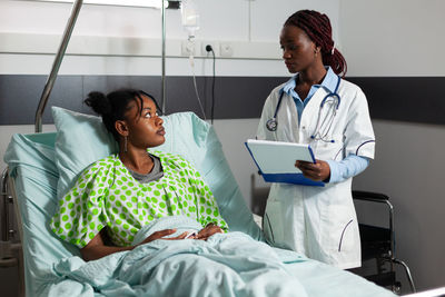 Female doctor examining patient in hospital