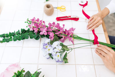 Midsection of florist making rose bouquet