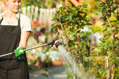 Full length of woman standing against plants in yard