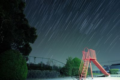 Low angle view of slide against meteor showers at night