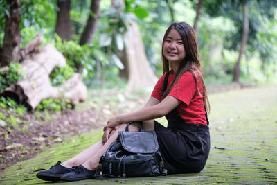 Portrait of smiling young woman sitting outdoors