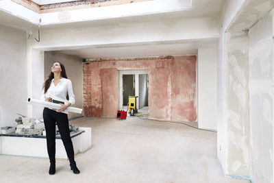 Woman in empty apartment looking around