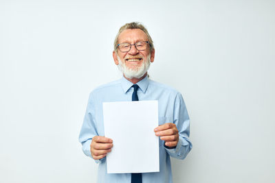 Portrait of smiling senior man against white background