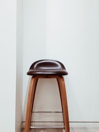 Close-up of empty seats on table against wall at home