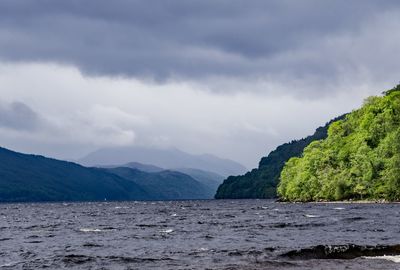 Scenic view of sea and mountains against sky