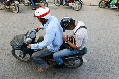 Man riding motor scooter on road