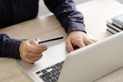 Midsection of man using laptop