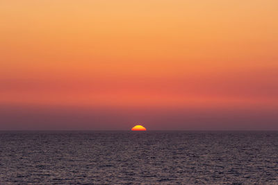 Scenic view of sea against romantic sky at sunset