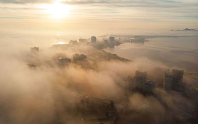 High angle view of buildings in city during sunset